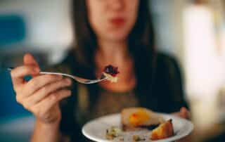 WOMAN HOLDING SWEET DESSERT OUT ON SPOON