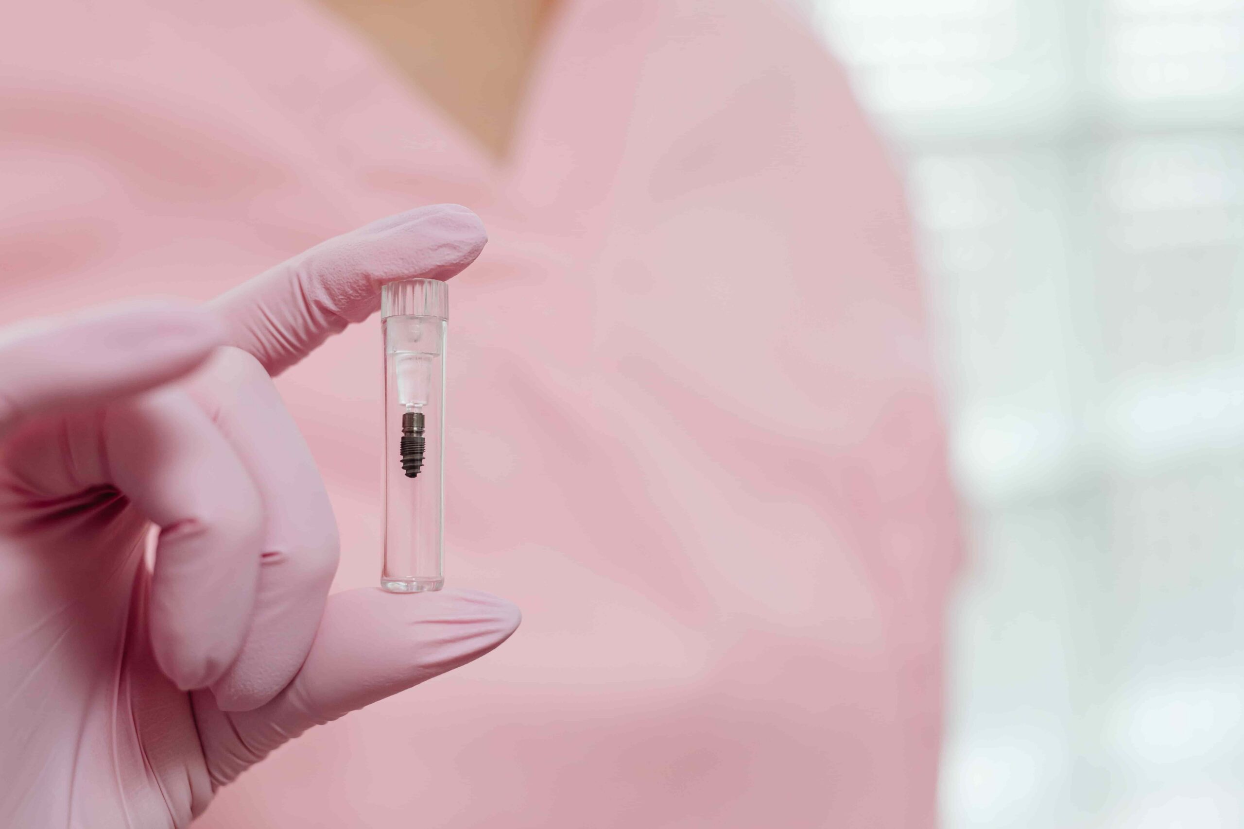What's the Real Cost of Dental Implants in California? 5 dentist holding up dental implant
