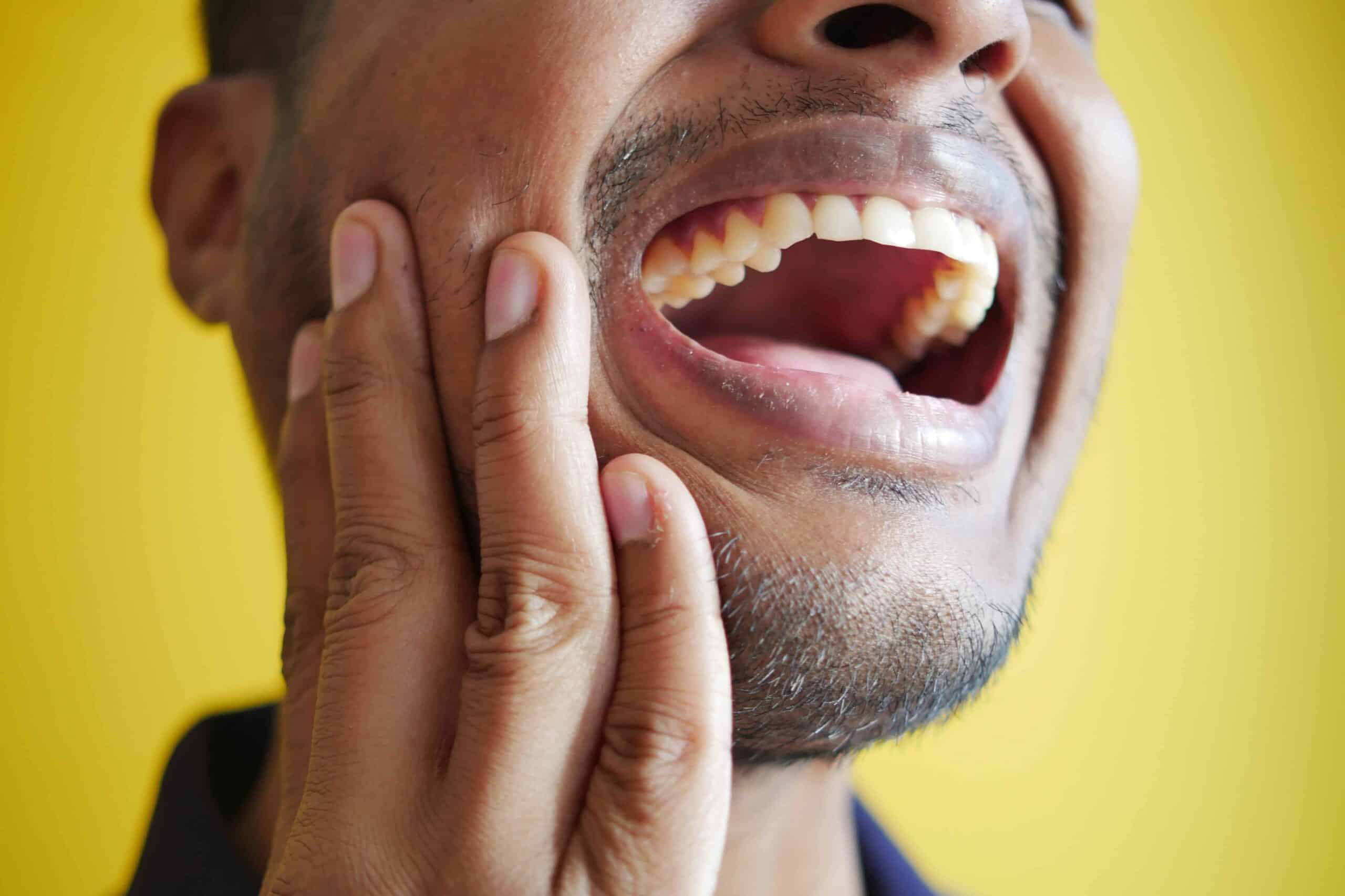 At-Home Tooth Pain Relief: Dentist-Approved Remedies 5 man holding mouth open in pain
